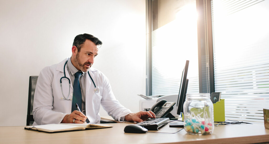 Doctor working on computer at his desk